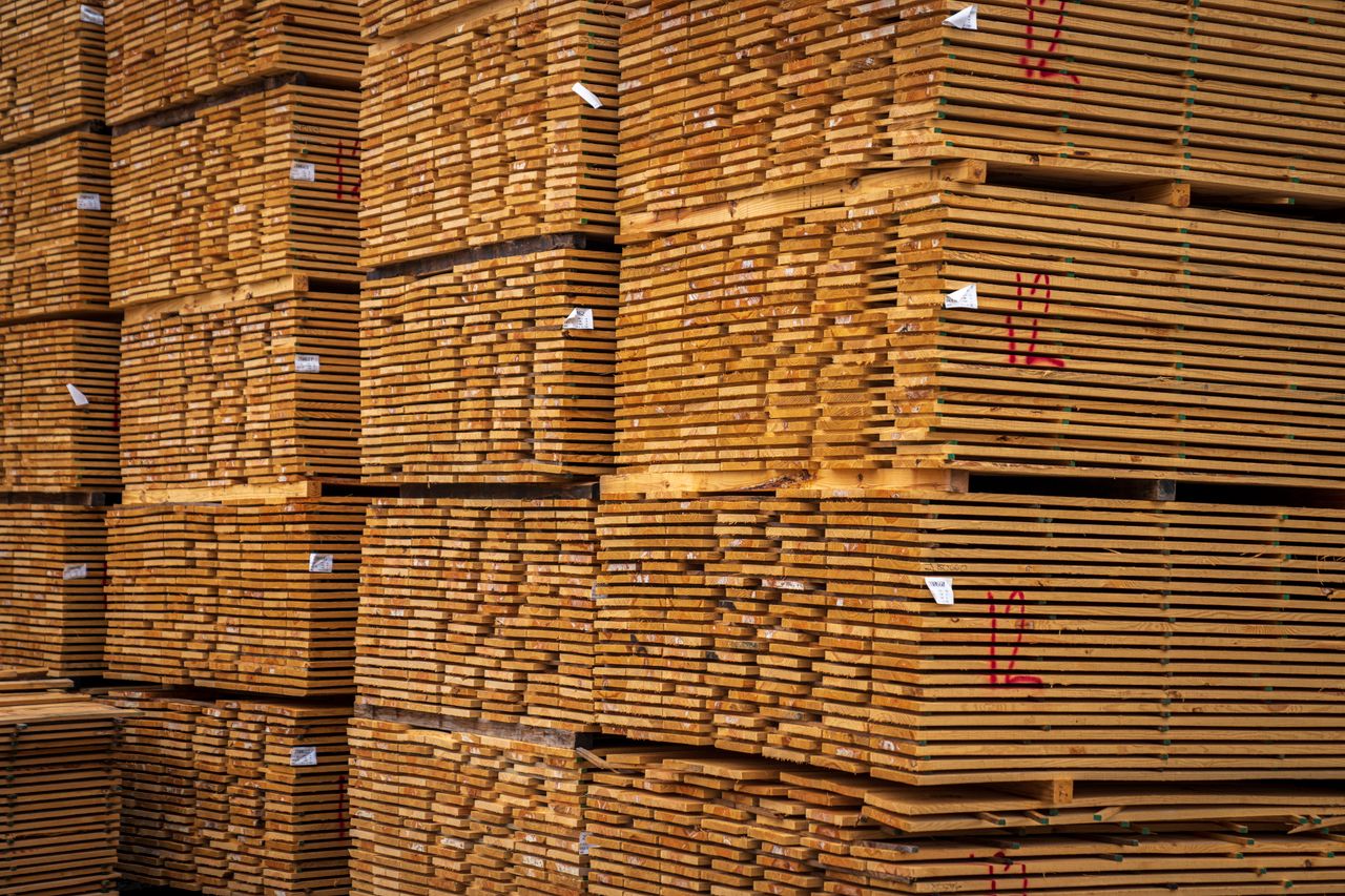 Close-up of neatly stacked wooden planks in an indoor warehouse setting.